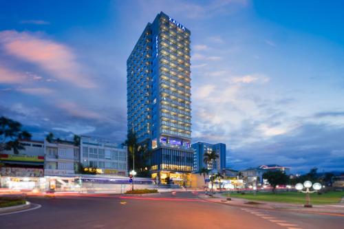 a tall building in a city at night at Xavia Hotel in Nha Trang
