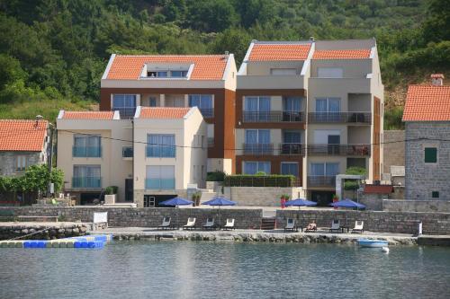 - un grand bâtiment à côté d'une étendue d'eau dans l'établissement Apartments Villa Jelena, à Tivat