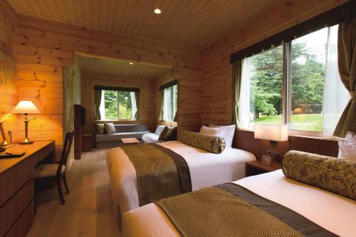 1 dormitorio con 2 camas en una cabaña de madera en The Prince Villa Karuizawa, en Karuizawa