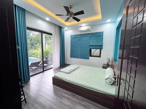 um quarto com uma cama e uma ventoinha de tecto em BlueHome Villa em Hòa Bình