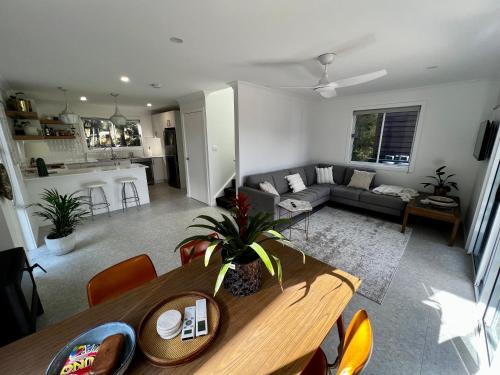 a living room with a table and a couch at Berrara Brand New Beach House in Berrara