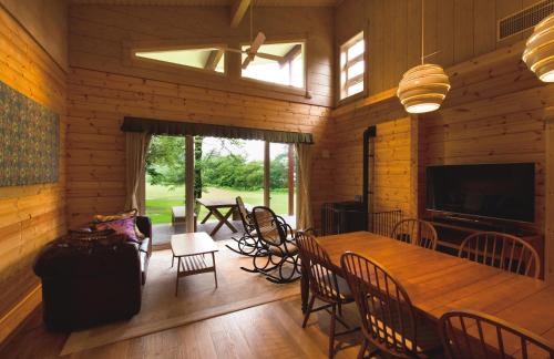 un comedor con una gran mesa de madera y sillas en The Prince Villa Karuizawa en Karuizawa