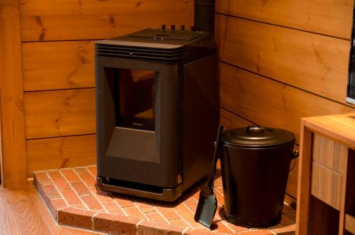 a wood stove with a trash can next to it at The Prince Villa Karuizawa in Karuizawa