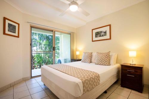 a bedroom with a bed and a large window at Port Douglas Sands Resort in Port Douglas