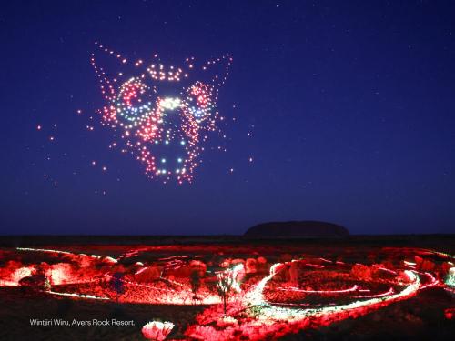 a night view of a lit up city with a cat sign at Sails in the Desert in Ayers Rock