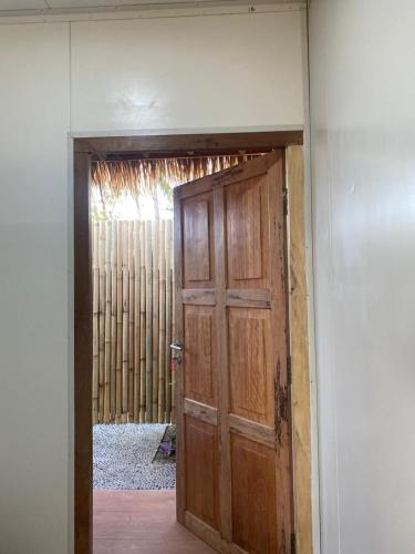 a wooden door in a room with a wall at Sumba Retreat Kerewe in Waikabubak