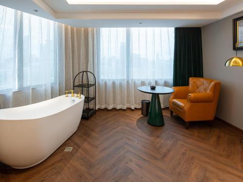 a bathroom with a large bath tub and a chair at Guangzhou Tianhe Taikoohui - Coffee Rupin Hotel,Canton Fair Free Shuttle Bus in Guangzhou