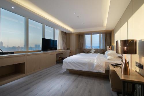 a hotel room with a bed and a television at Guangzhou Tianhe Taikoohui - Coffee Rupin Hotel,Canton Fair Free Shuttle Bus in Guangzhou