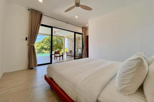 a bedroom with a white bed and a sliding glass door at Villa Marie, 2 Bedrooms, Lamai Koh Samui in Koh Samui 