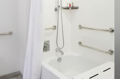a bathroom with a shower and a white sink at Marriott Cincinnati Airport in Hebron