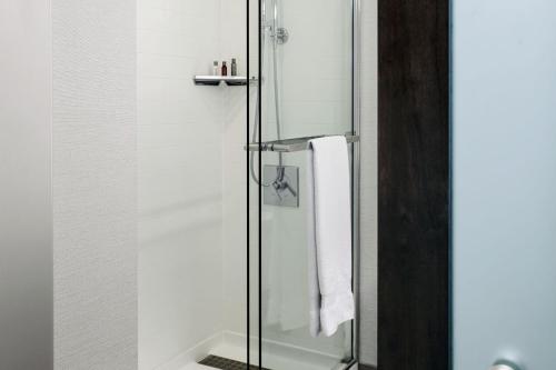 a bathroom with a shower with a glass door at Marriott Cincinnati Airport in Hebron