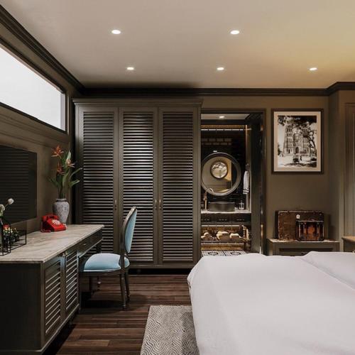 a bedroom with a bed and a desk and a kitchen at Casa Dos Príncipes Hotel & Spa in Hanoi
