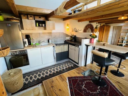 a kitchen with white cabinets and a wooden floor at Bali-Style Tinyhaus am Wald in Bruckberg