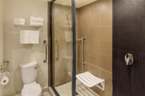 a bathroom with a toilet and a glass shower at Protea Hotel by Marriott Ndola in Ndola