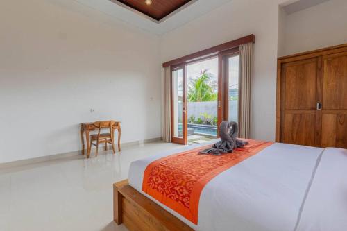 een slaapkamer met een bed, een tafel en een raam bij New Private Pool Villa - Villa Dhea Ubud in Ubud