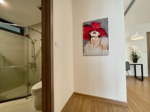 un baño con una pintura de una mujer con sombrero rojo en Vinhomes Skylake Apartments next to Keangnam,High floor City view with Balcony, en Hanói