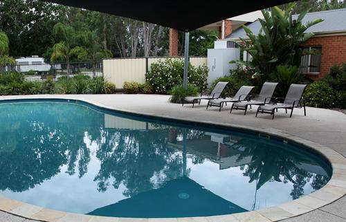 a swimming pool with chairs sitting around it at Cohuna Waterfront Holiday Park in Cohuna