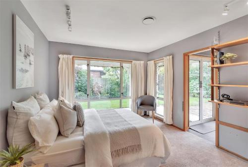 sypialnia z łóżkiem i dużym oknem w obiekcie Sweet Home w mieście Christchurch