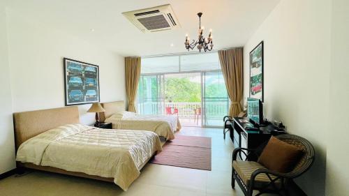 1 dormitorio con 2 camas, silla y ventana en Baan Ing Khao, en Pak Chong