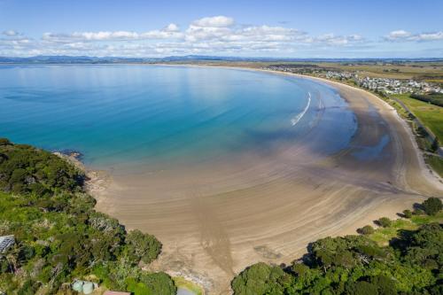 an aerial view of a beach and the ocean at Tokerau Magic - Karikari Peninsula Holiday Home in Kaitaia