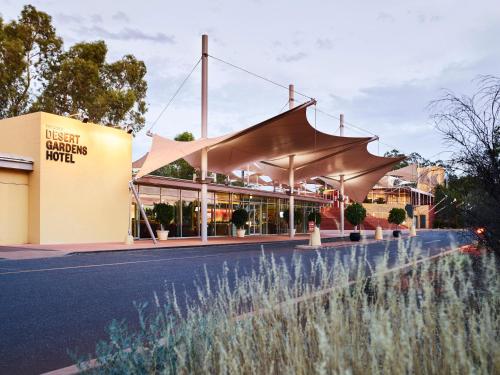 a building with awning on the side of a road at Desert Gardens Hotel in Ayers Rock