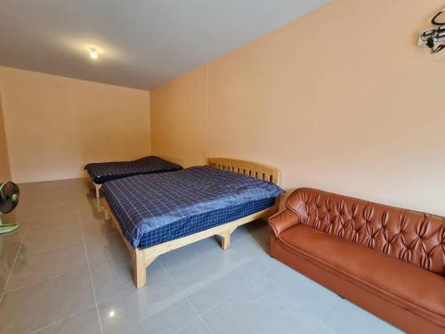 ein Schlafzimmer mit einem Bett und einem Sofa in der Unterkunft Khunkhao Maenamchan Homestay ขุนเขา แม่น้ำจัน โฮมสเตย์ in Chiang Rai