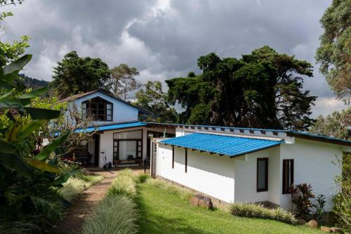 a white house with a blue roof at La Maima in Dapa