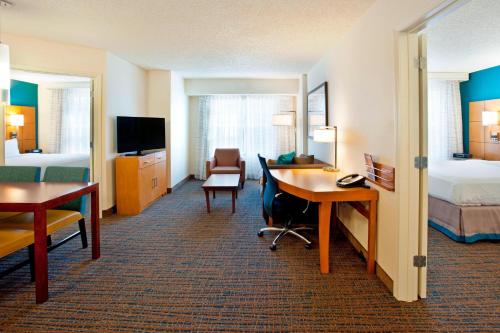 a hotel room with a desk and a bedroom at Residence Inn Bridgewater Branchburg in Branchburg Park