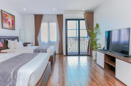 ein Hotelzimmer mit 2 Betten und einem Flachbild-TV in der Unterkunft Yên Phong Hotel 