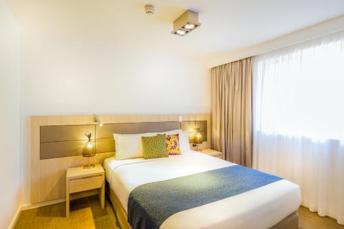 Una cama o camas en una habitación de Emu Walk Apartments