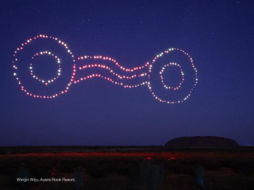 un groupe de lumières dans le ciel la nuit dans l'établissement The Lost Camel Hotel, à Uluru