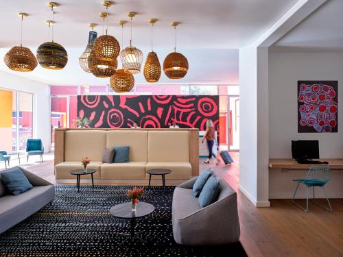 a living room with two couches and a colorful wall at The Lost Camel Hotel in Ayers Rock