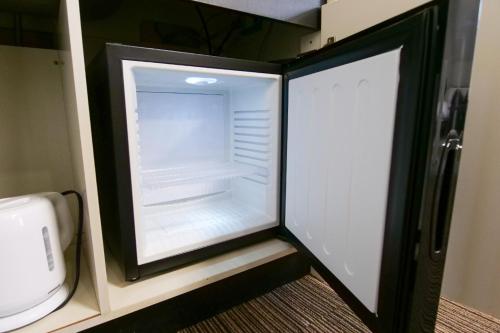 un réfrigérateur vide avec sa porte ouverte dans une cuisine dans l'établissement J-Court Oshiage, à Tokyo