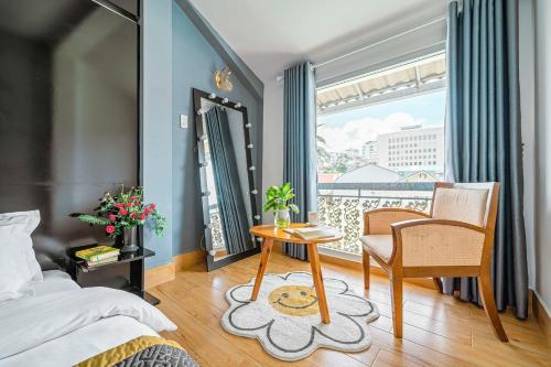 a bedroom with a bed and a table and a window at Villa Hẻm Đà Lạt in Da Lat
