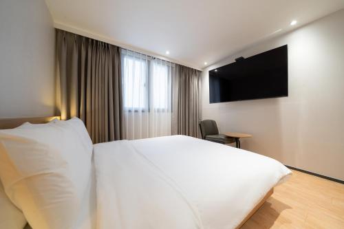 pokój hotelowy z łóżkiem i telewizorem z płaskim ekranem w obiekcie Hotel 23 w mieście Ulsan