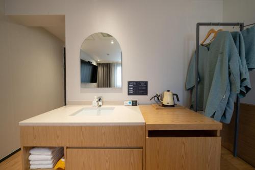 W łazience znajduje się umywalka i lustro. w obiekcie Hotel 23 w mieście Ulsan