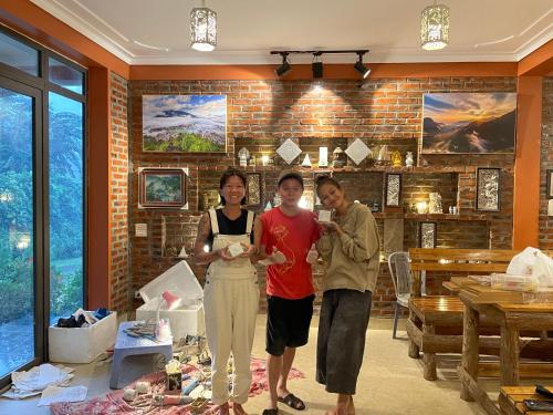 a group of three people standing in a room at Stone Paradise Homestay in Sapa