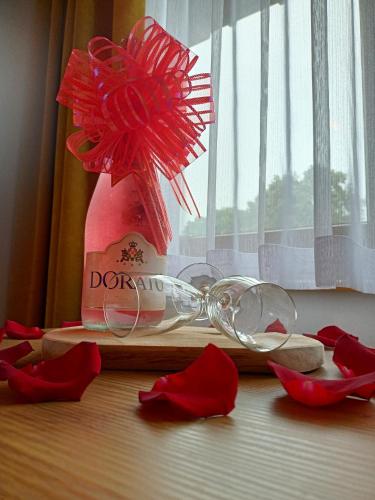 a wine glass and red flowers on a table at Cicha Woda 300 m od Gorący Potok i Termy Szaflary in Szaflary