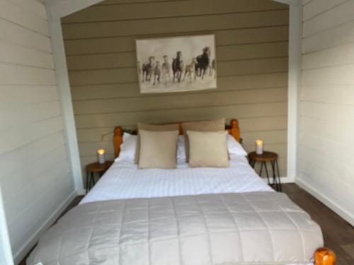 a bedroom with a white bed with two tables at The Haystack in Oswestry