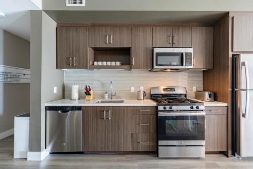 cocina con armarios de madera, fogones y microondas en New Construction Modern Luxury Views Pool & Patio, en Los Ángeles