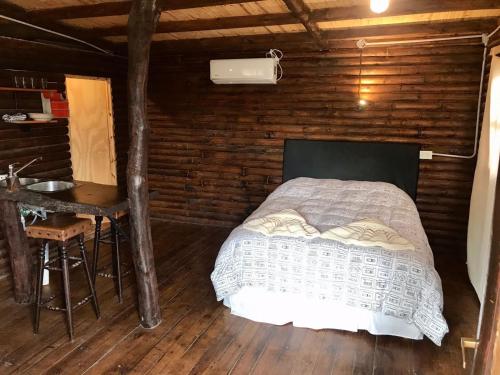 a bedroom with a bed in a wooden cabin at CABAÑAS COSTA RIBERA in Timbues