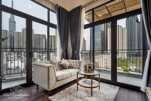 a living room with a couch and large windows at KunKin Garden Aparthotel in Ho Chi Minh City