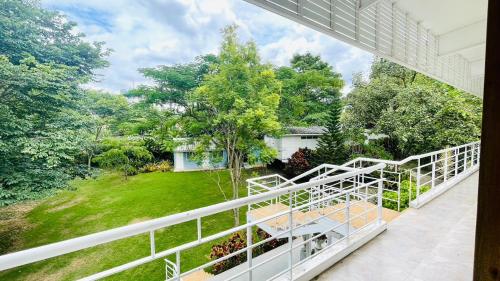 a balcony with a view of a yard at Baan Ing Khao in Pak Chong