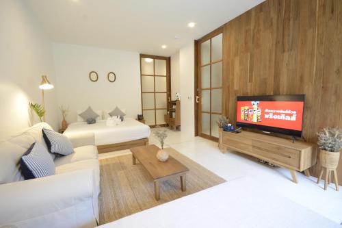 a living room with a couch and a tv at Proud Phu Fah Muang Chiang Mai in Chiang Mai