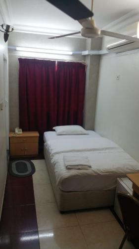 a bedroom with a bed with a red curtain at Sun City Hotel in Muscat