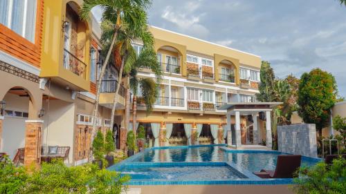 a hotel with a swimming pool in front of a building at Ragazzi Resort Hotel in Naga