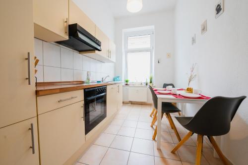 a kitchen with a table and chairs in a kitchen at Blue Chili 02 - MD Zentral City Carré Wlan in Magdeburg
