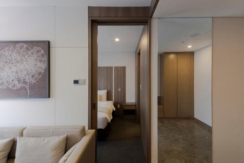 a hotel room with a couch and a bed at Amid Hotel Seoul in Seoul
