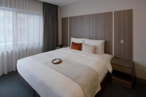 a large white bed in a hotel room at Amid Hotel Seoul in Seoul