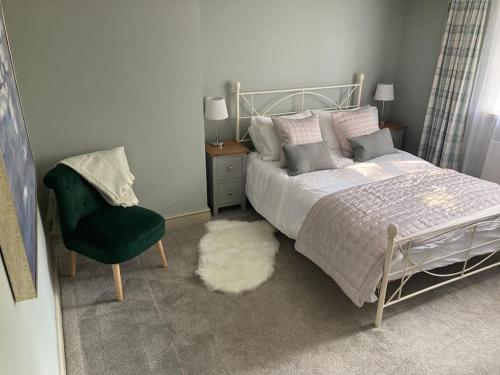 een slaapkamer met een bed, een stoel en een tapijt bij Spacious Cottage in Idyllic Spot in Fenny Compton